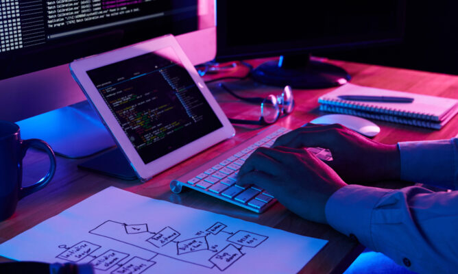 Close-up image of programmer working at his desk in office